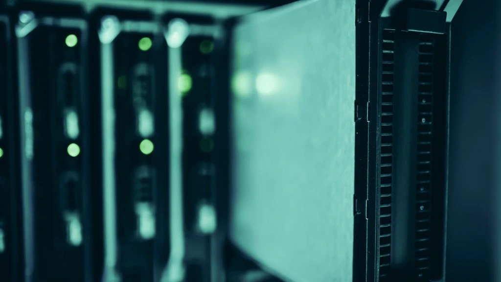 A server rack aisle with bicolor status LEDs in a darkened data center